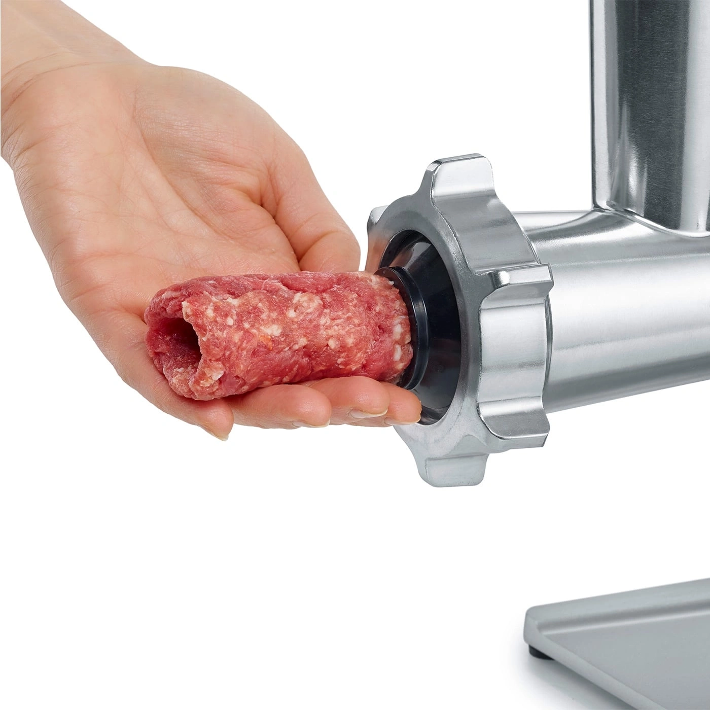 Gros plan d'une main tenant de la viande, hachoir à viande, fond blanc