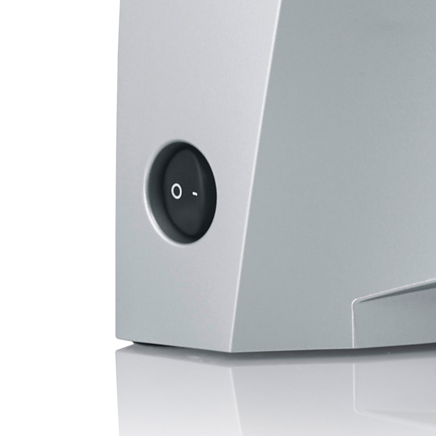 Close-up of a gray device with a round on-off switch, detail shot