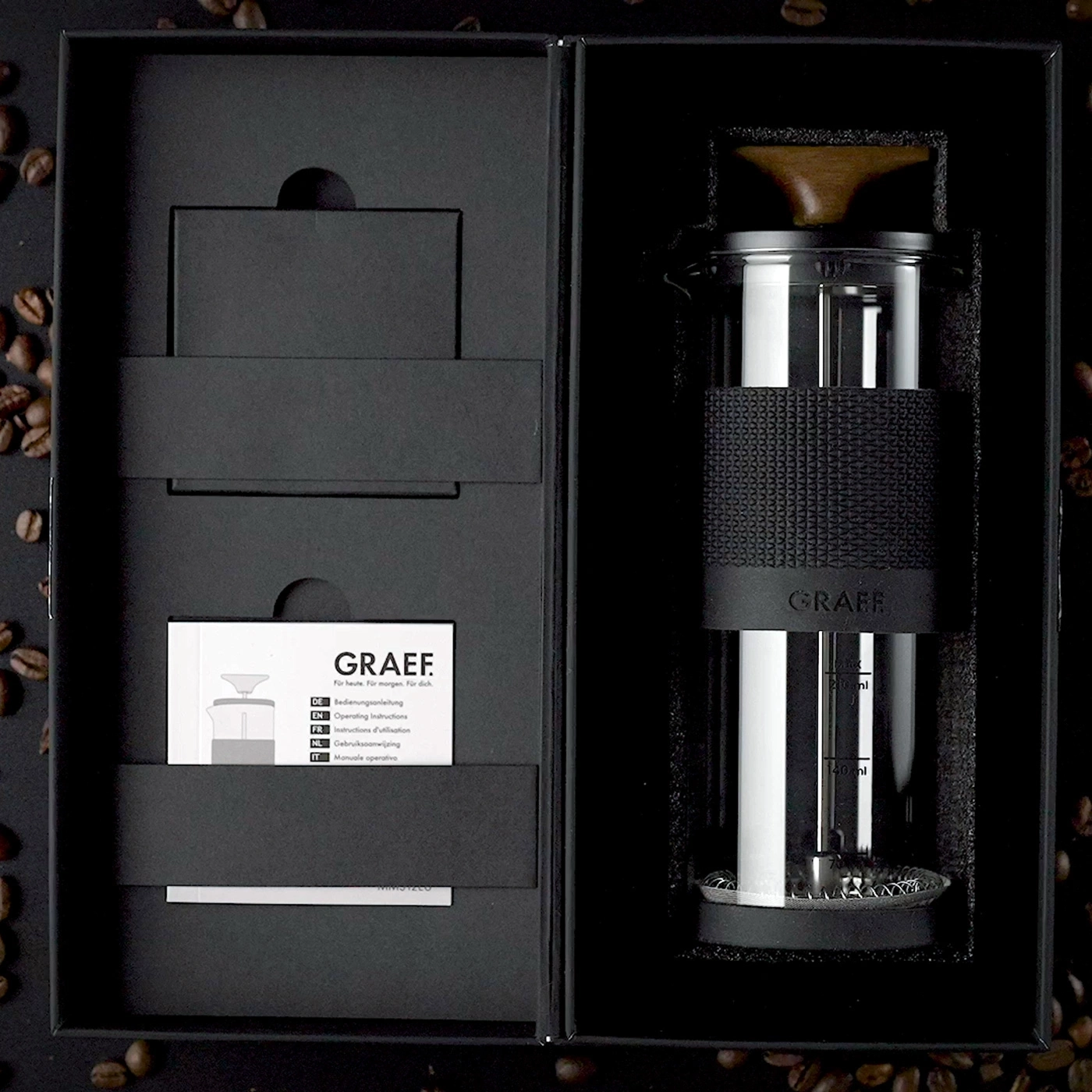 Cafetière GRAEF dans une boîte cadeau noire avec des grains de café.