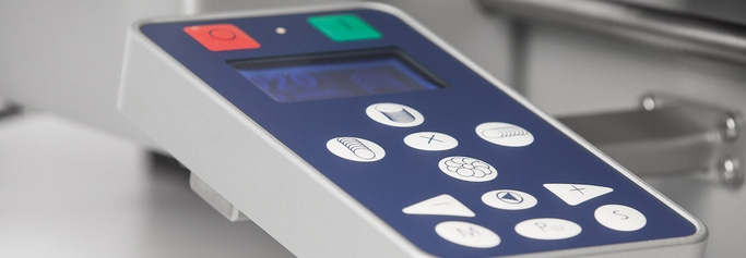 Primo piano di un pannello di controllo blu e grigio con pulsanti e display