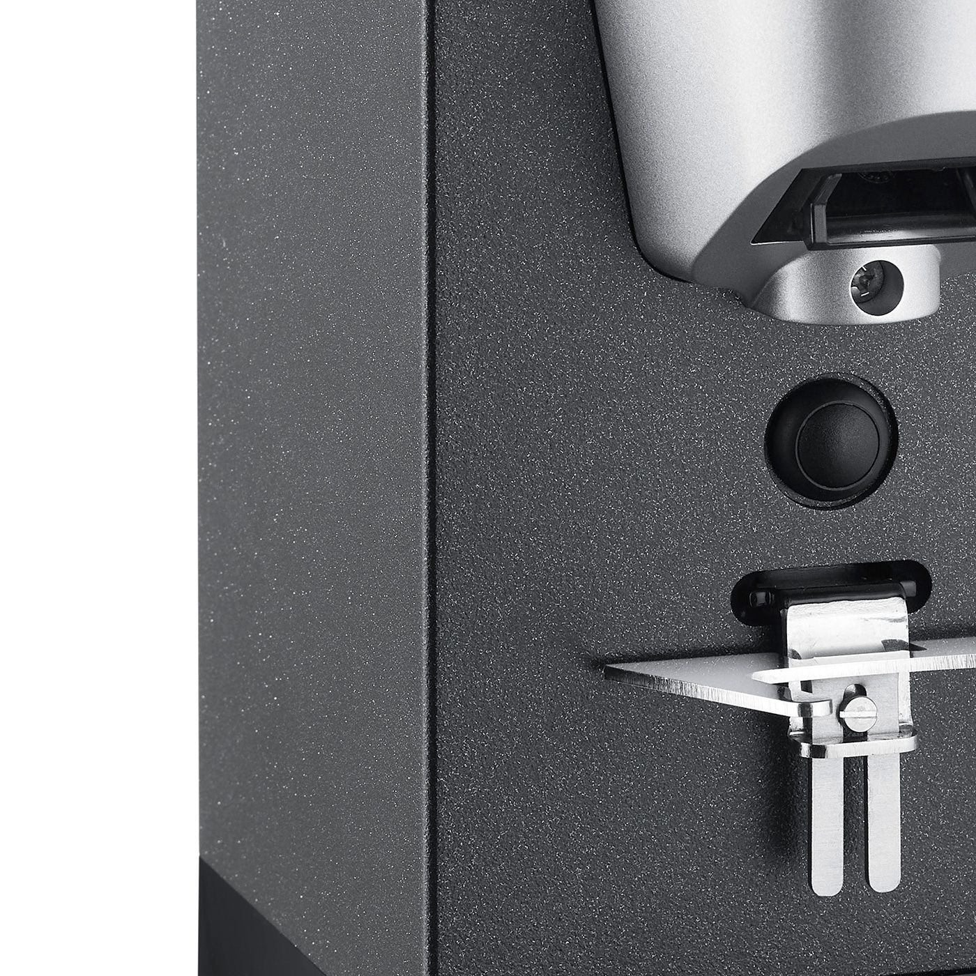 Close-up of a black device with a button and a metal part