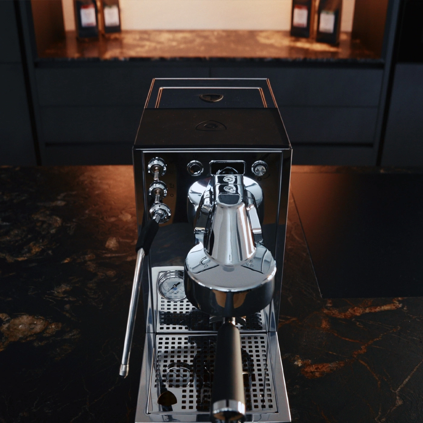 Une machine à expresso brillante sur un comptoir en marbre sombre dans une cuisine moderne.