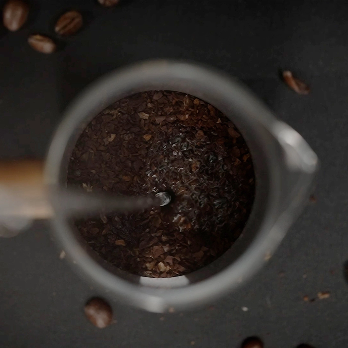 Fondi di caffè con acqua in un contenitore di vetro, primo piano