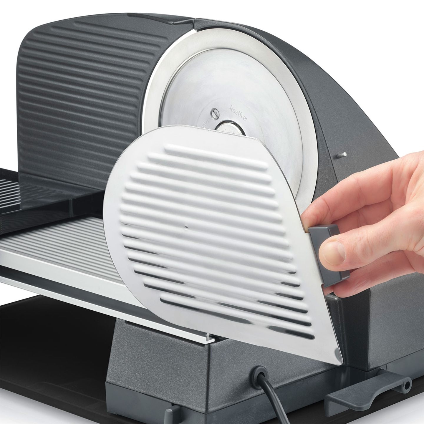 Affettatrice di carne con protezione azionata da una mano.