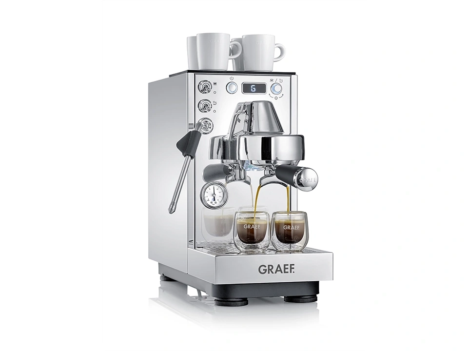 Une machine à expresso chromée brillante avec deux tasses de café et deux tasses sur le dessus.