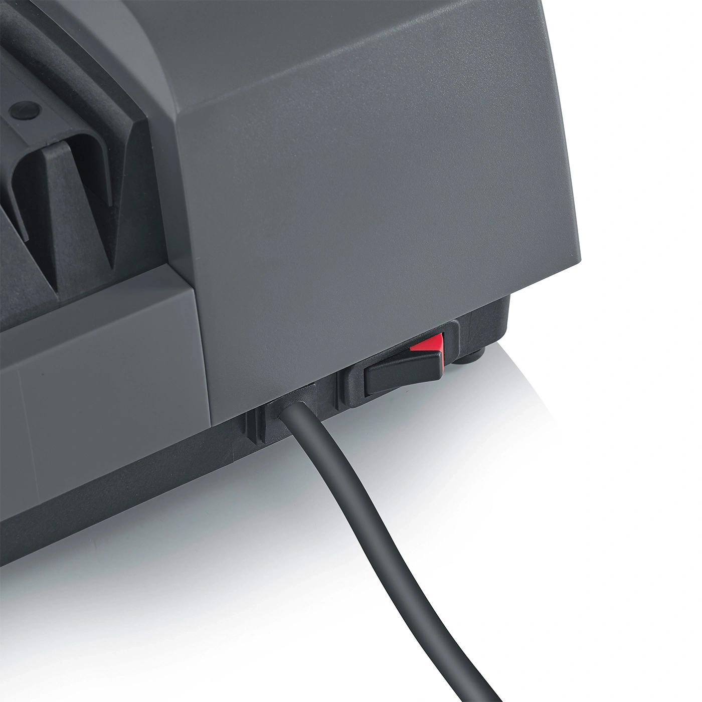 Primo piano di un dispositivo grigio con interruttore rosso e cavo nero