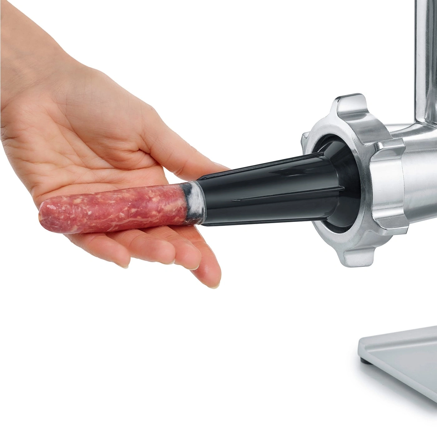 Saucisse poussée dans un hachoir à viande, gros plan, main, viande, nourriture