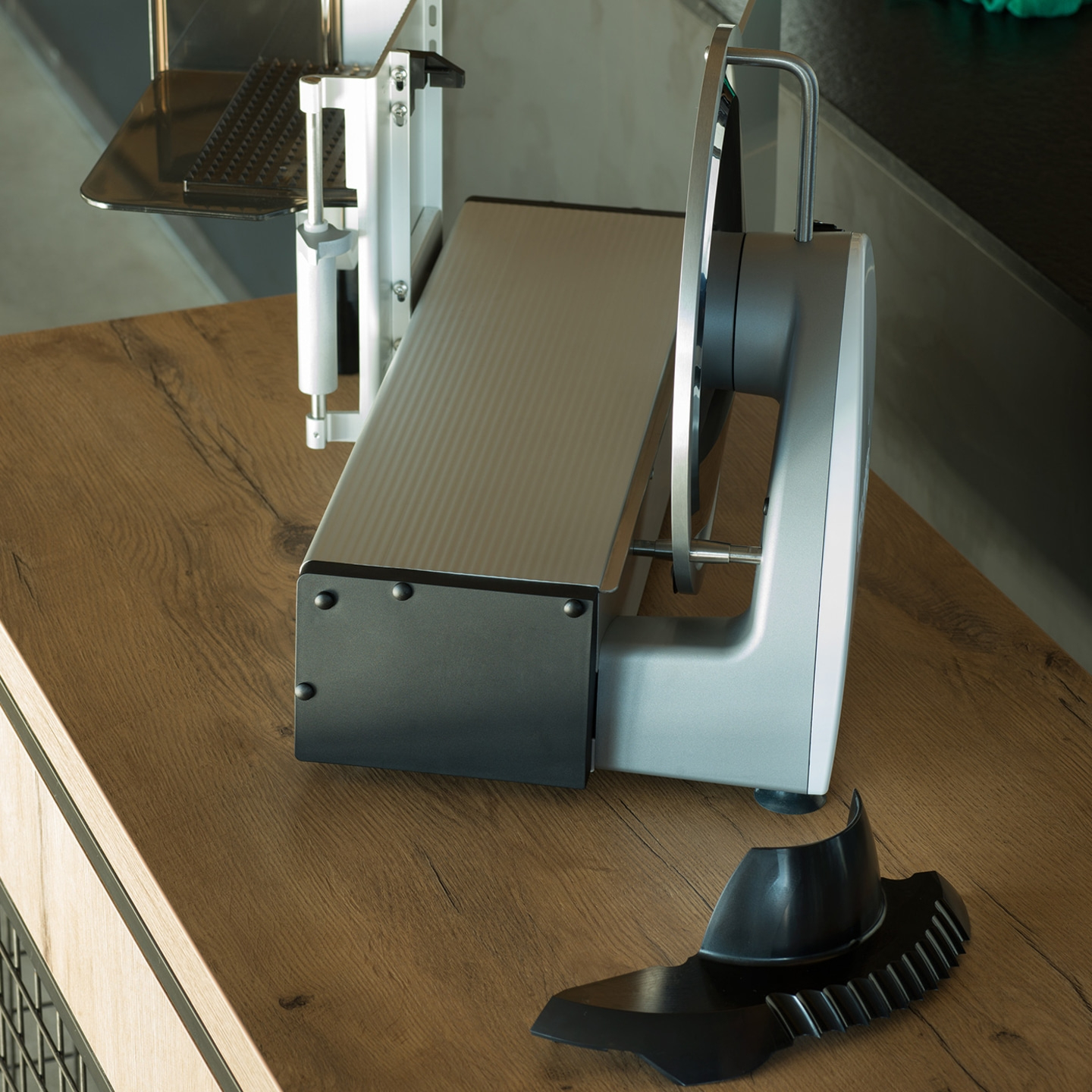 Affettatrice elettrica su superficie in legno, con parti staccabili, pronta all'uso.