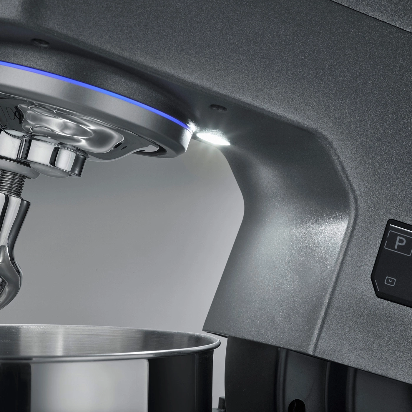 Primo piano di un mixer da cucina grigio con illuminazione blu e pannello di controllo