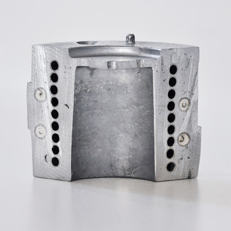 Metal block with holes and a hole in the middle, gray color