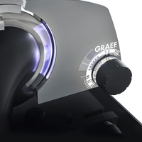 Détail de la trancheuse Graef, bouton, surface grise, lumière bleue, nom de la marque, machine