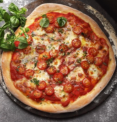 Pizza with tomatoes, basil, and cheese on a wooden board
