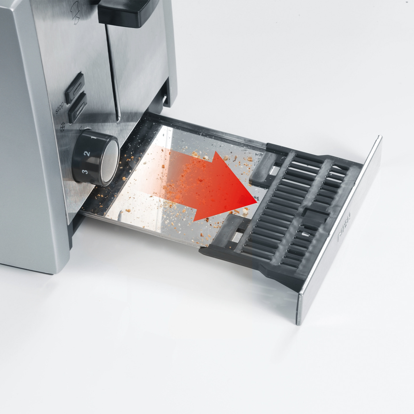 Toaster with crumb tray pulled out, red arrow indicating direction, and crumbs visible.