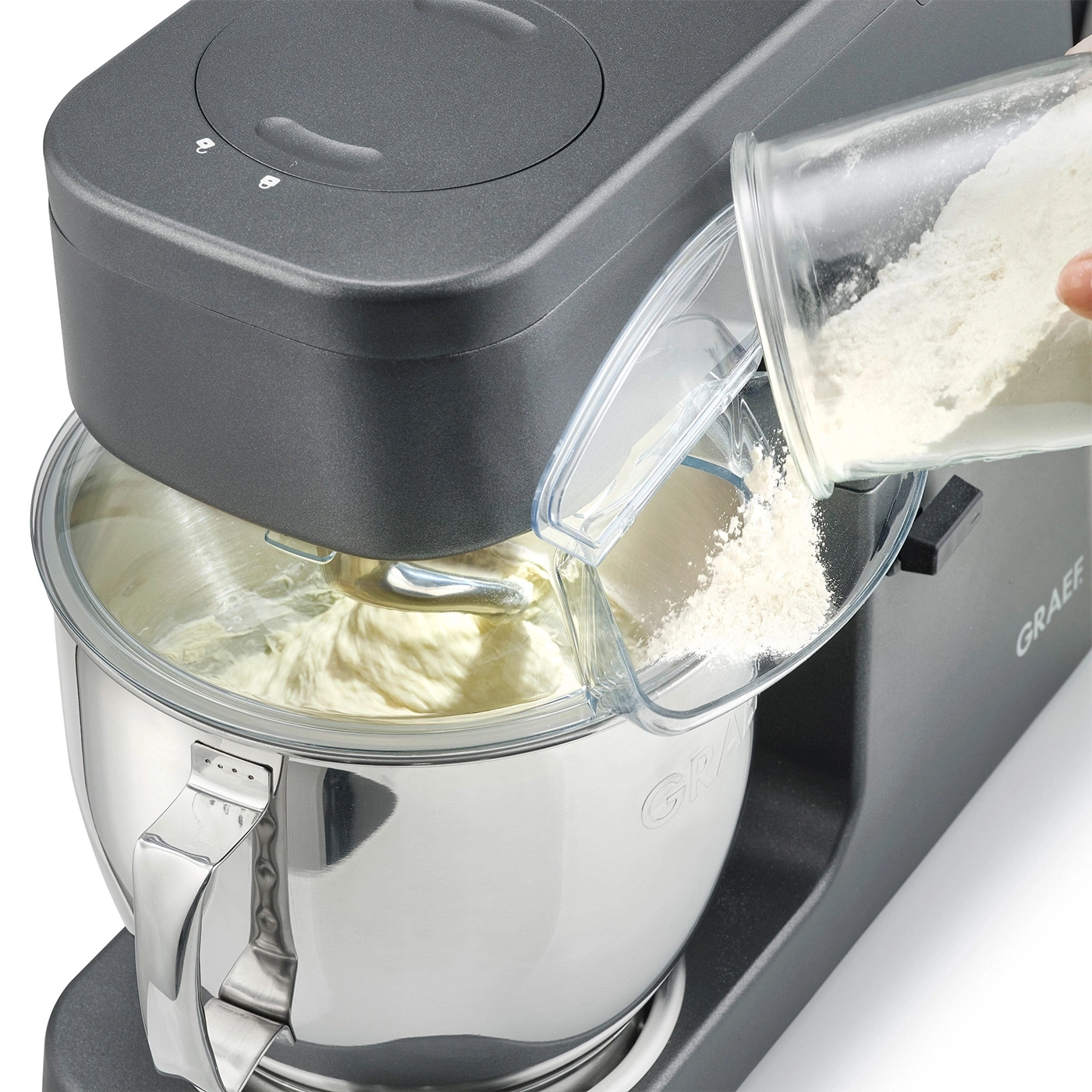 Robot da cucina con aggiunta di farina in una ciotola di impasto. Graef.