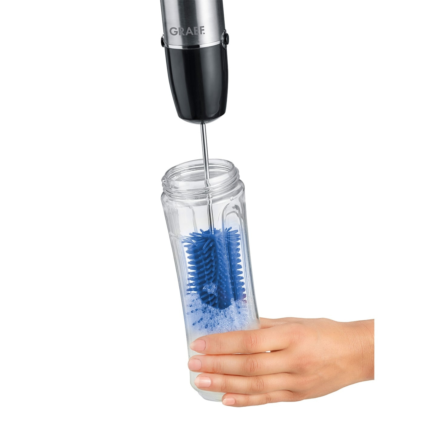 A hand holding a glass being cleaned by a blue brush.