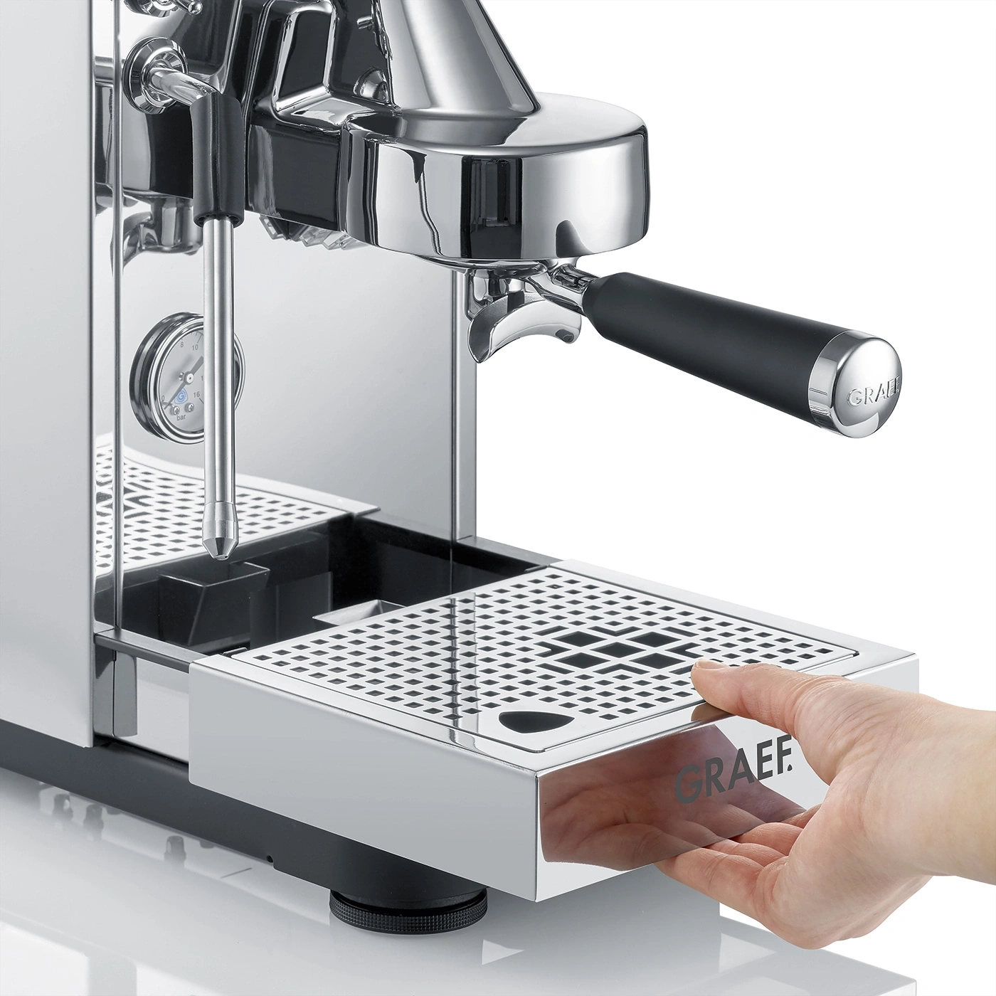 Une main retire le bac d'égouttement d'une machine à café.