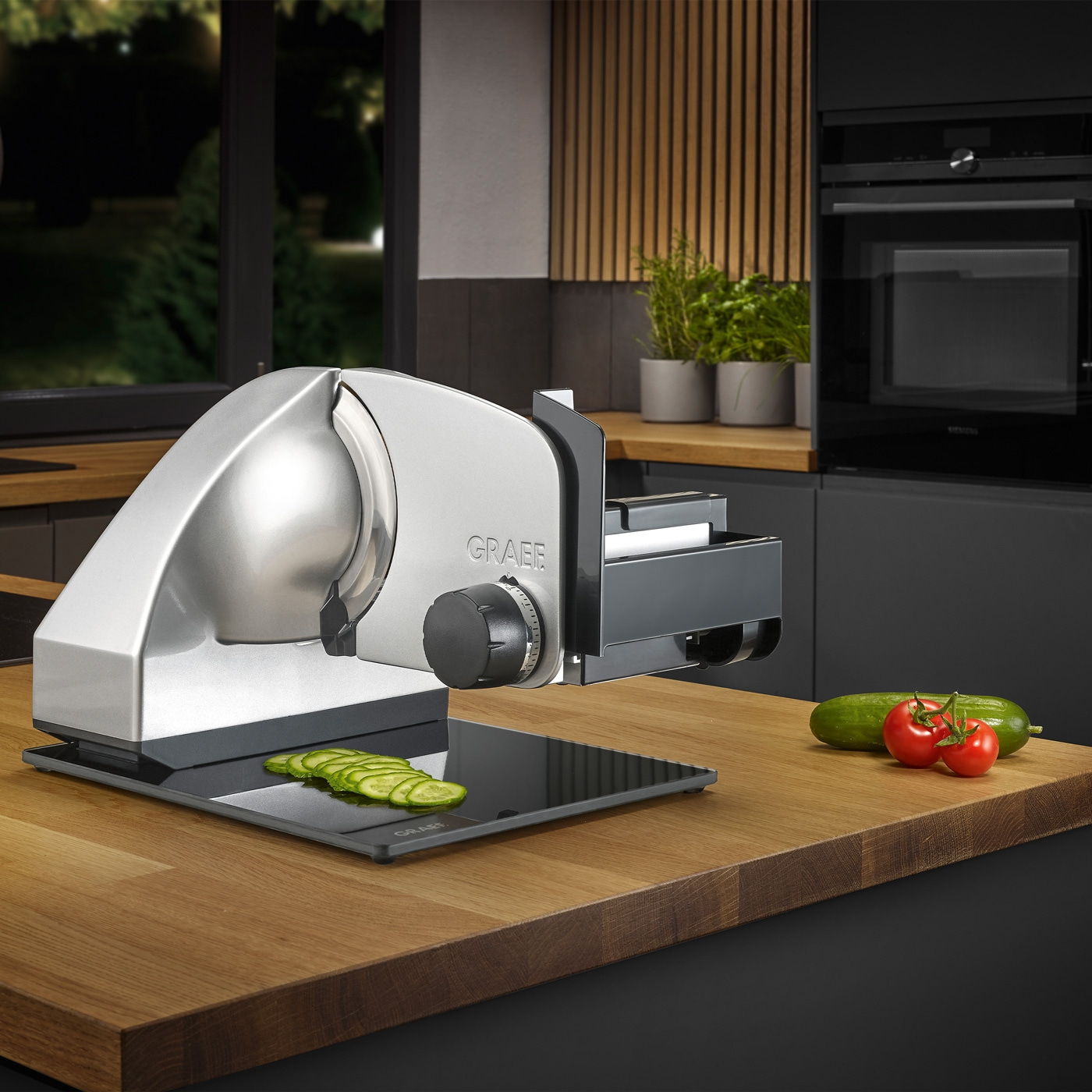 Affettatrice elettrica con verdure su una superficie di legno in cucina.