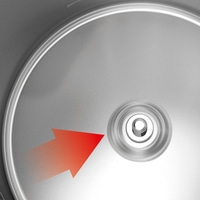 Red arrow pointing to a silver circular object with a hole in the center.