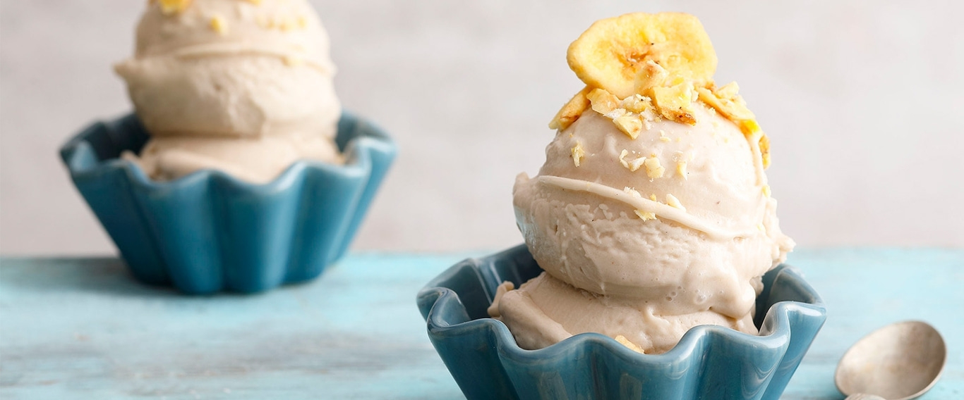 Ice cream in blue bowls, topped with banana slices and nuts