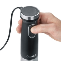Black hand blender with dial and button, held by a hand, close-up shot