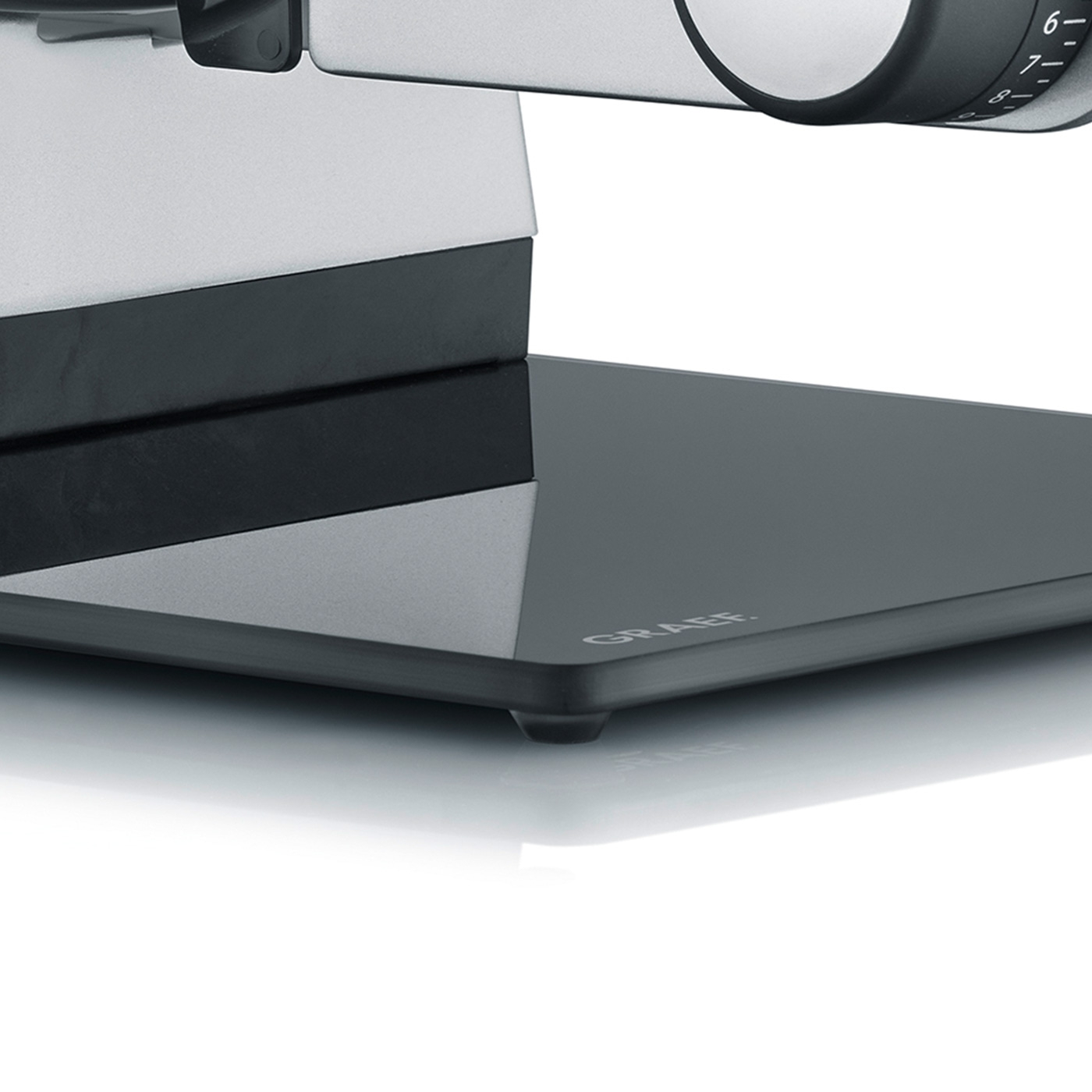 Primo piano di un'affettatrice grigia con la scritta GRAEF sulla base.