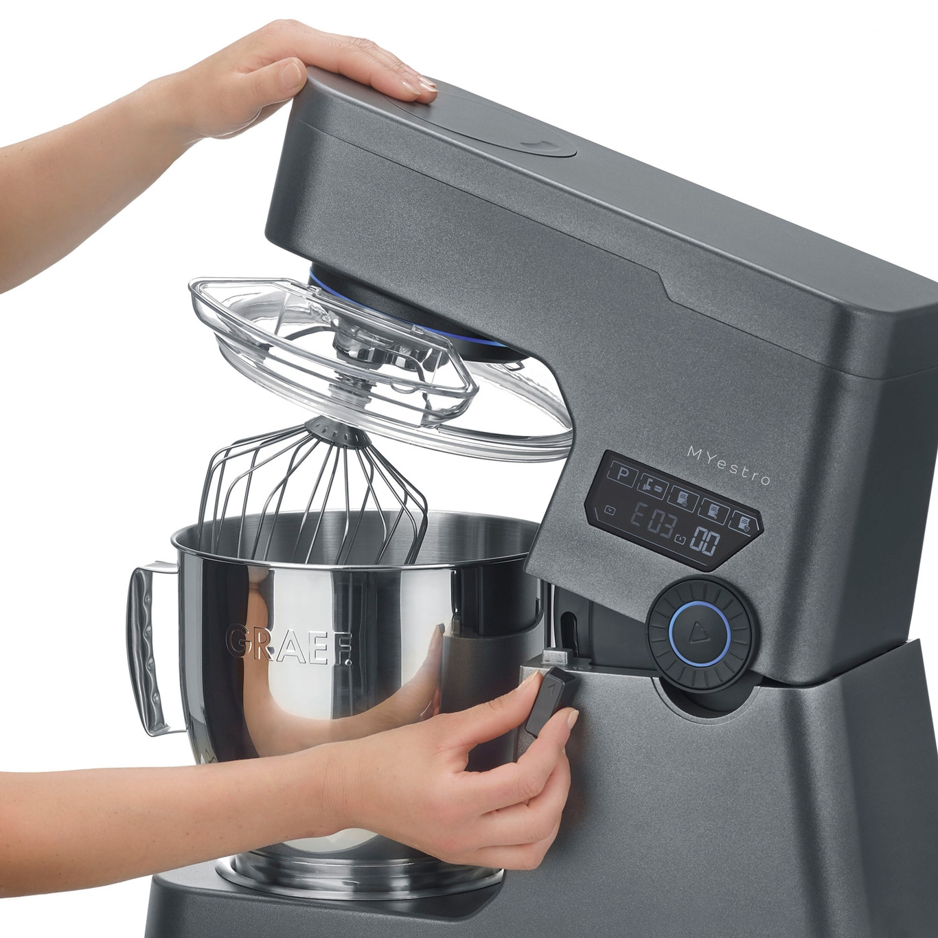 Robot de cuisine gris avec accessoires et commandes, gros plan, mains en action