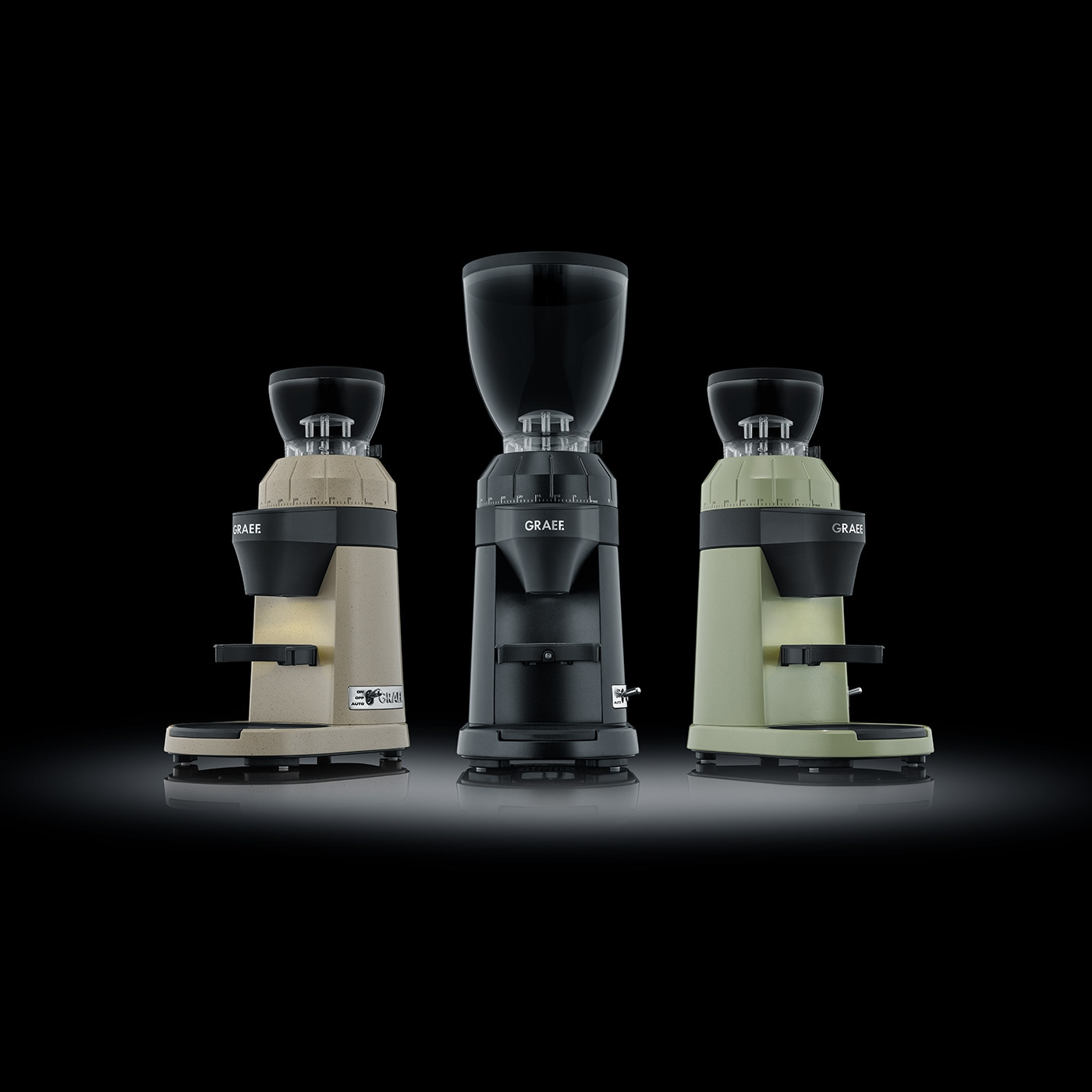 Three coffee grinders in different colors against a black background.