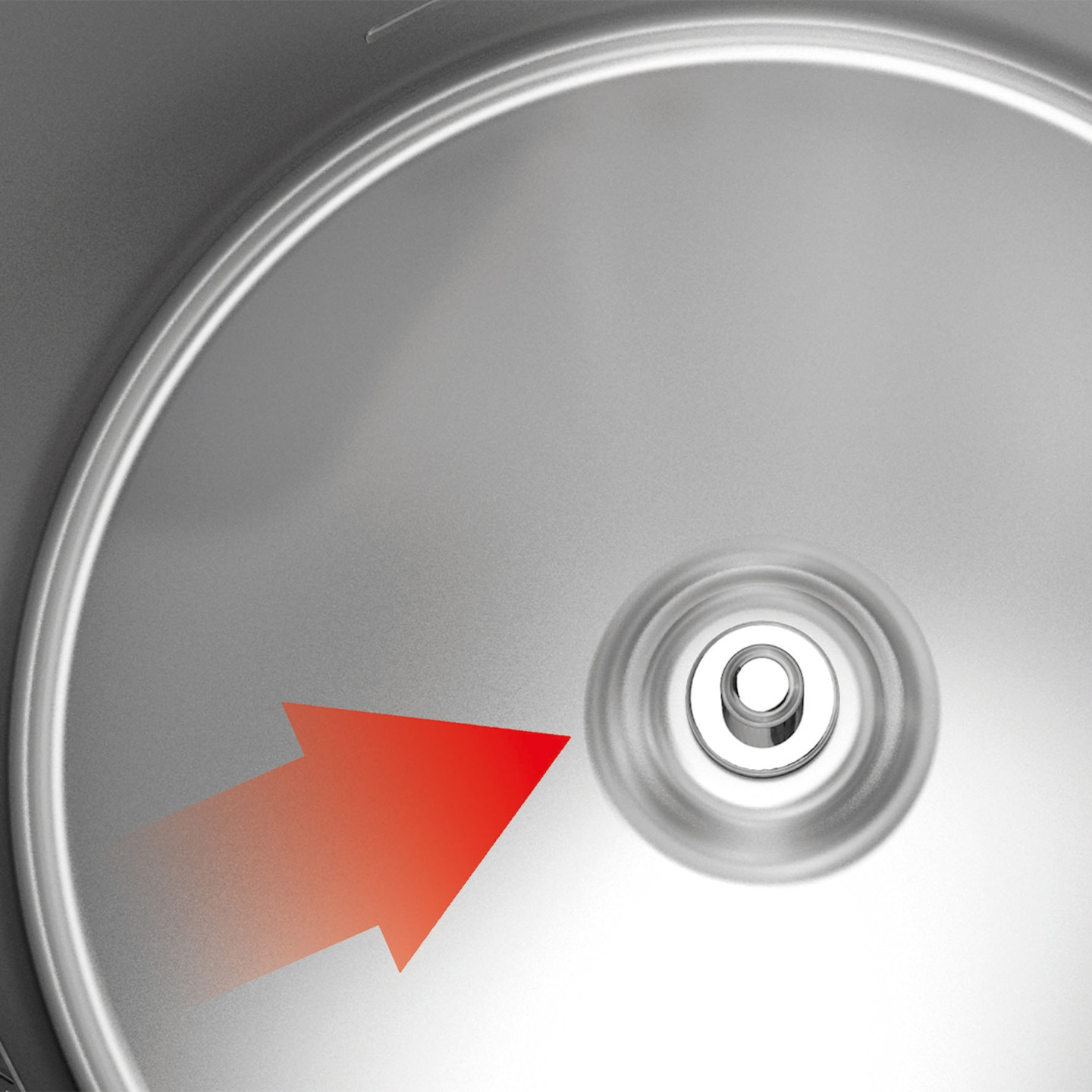 Red arrow pointing to a silver circular object with a hole in the center.