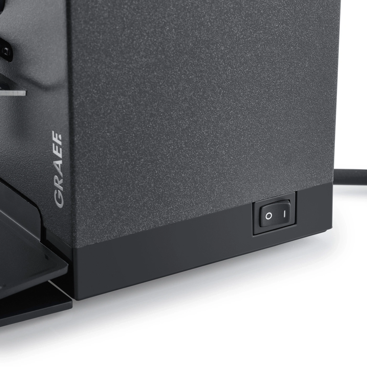 Graef device with on/off switch. Black casing, texture, detail shot, close-up.