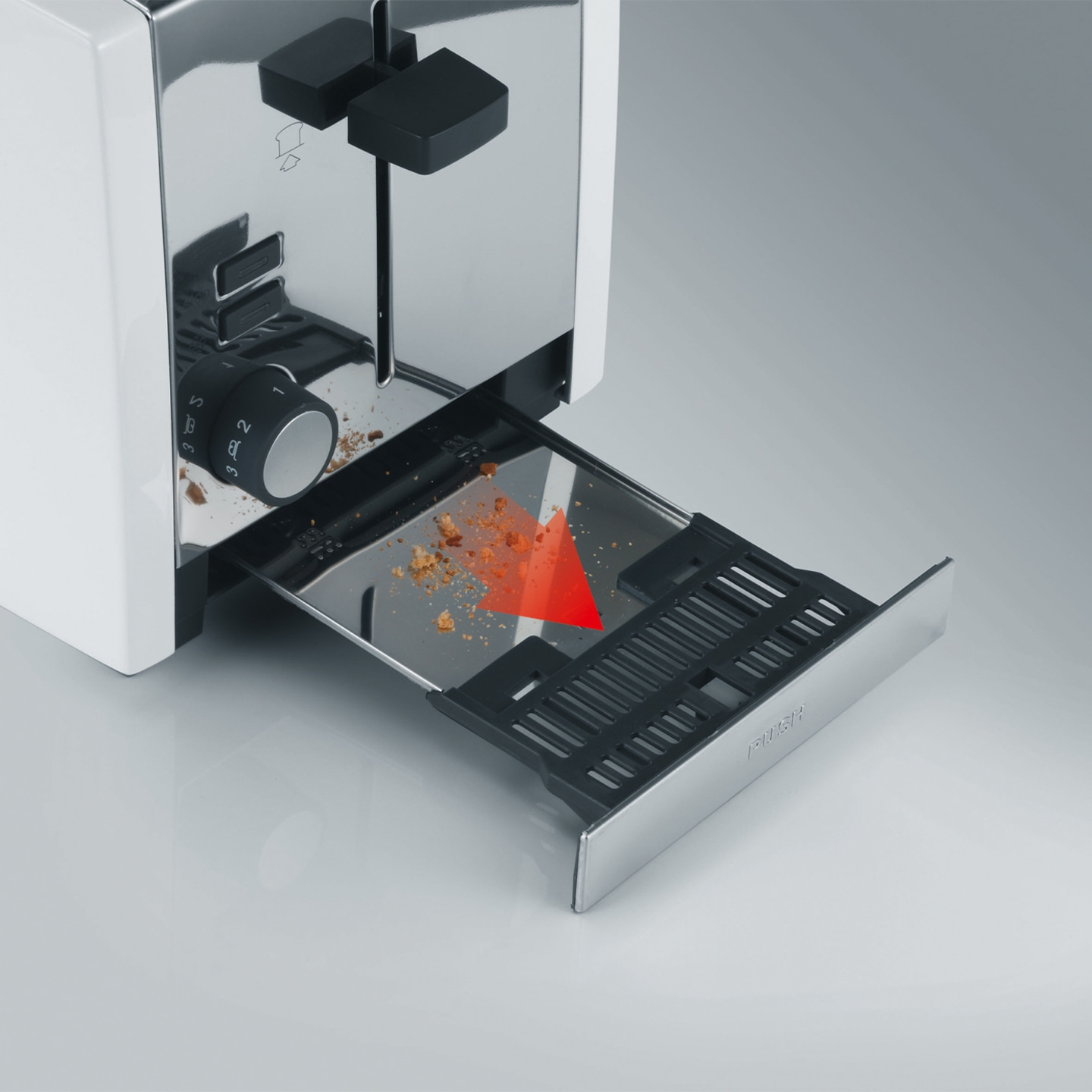 Grille-pain avec tiroir ramasse-miettes amovible et flèche rouge indiquant la direction.