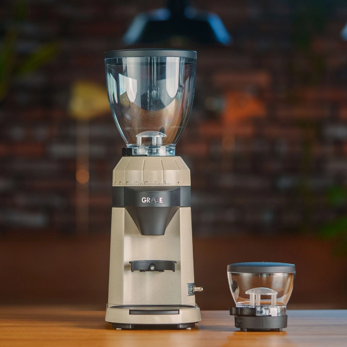 Macinacaffè con contenitore e contenitore di raccolta su superficie in legno