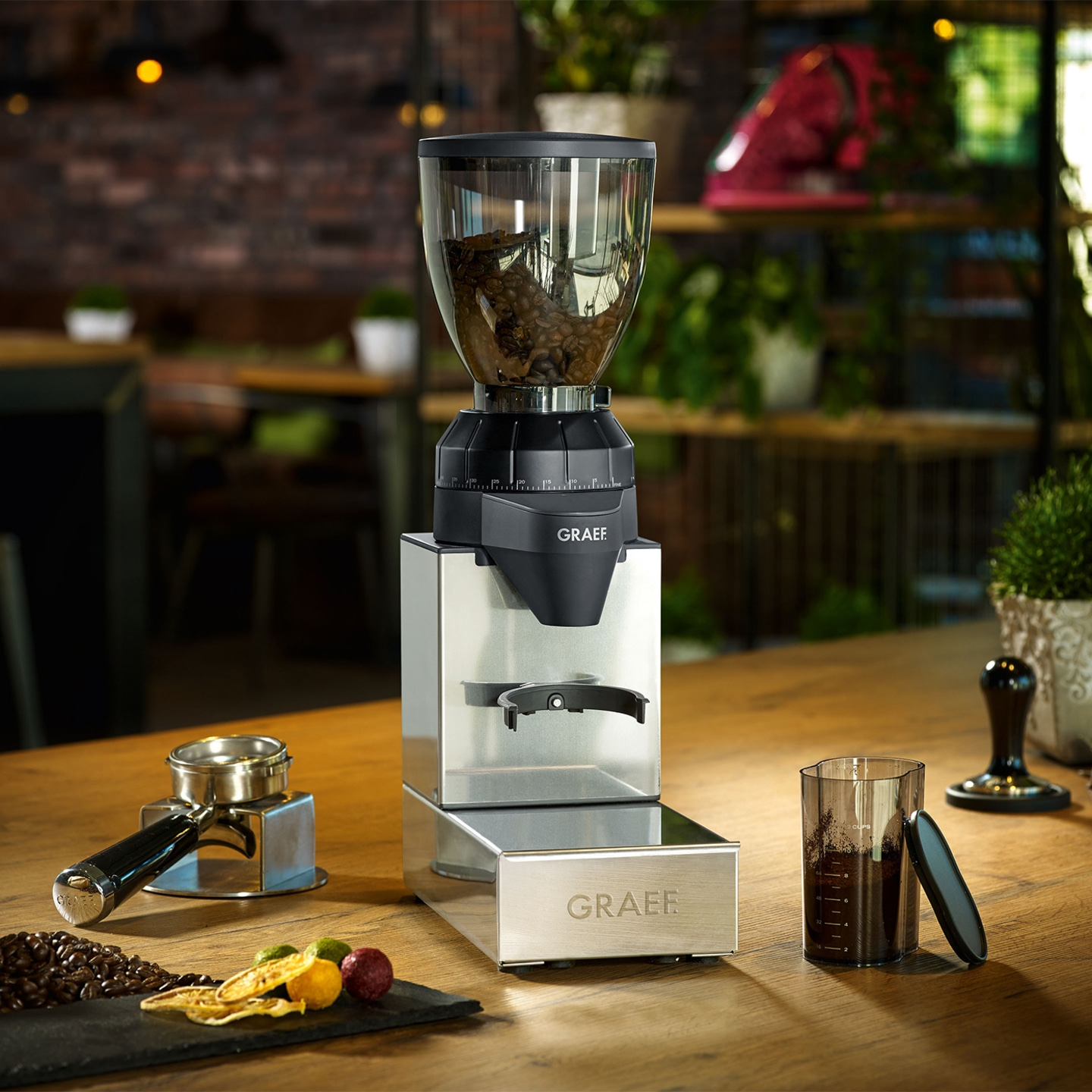 Coffee grinder with accessories on a wooden table in a cafe