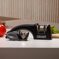 Affûteur de couteaux noir avec logo GRAEF sur table blanche avec tomate et basilic.