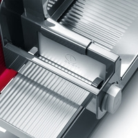 Gros plan d'une trancheuse à viande argentée avec interrupteur marche/arrêt.