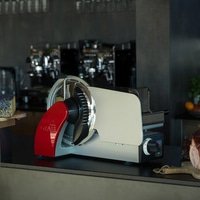Graef slicer on a counter with cheese and meat in the background