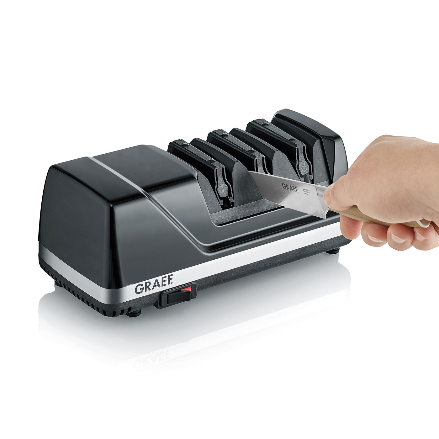 Graef knife sharpener, sharpening knives, hand holding knife, black