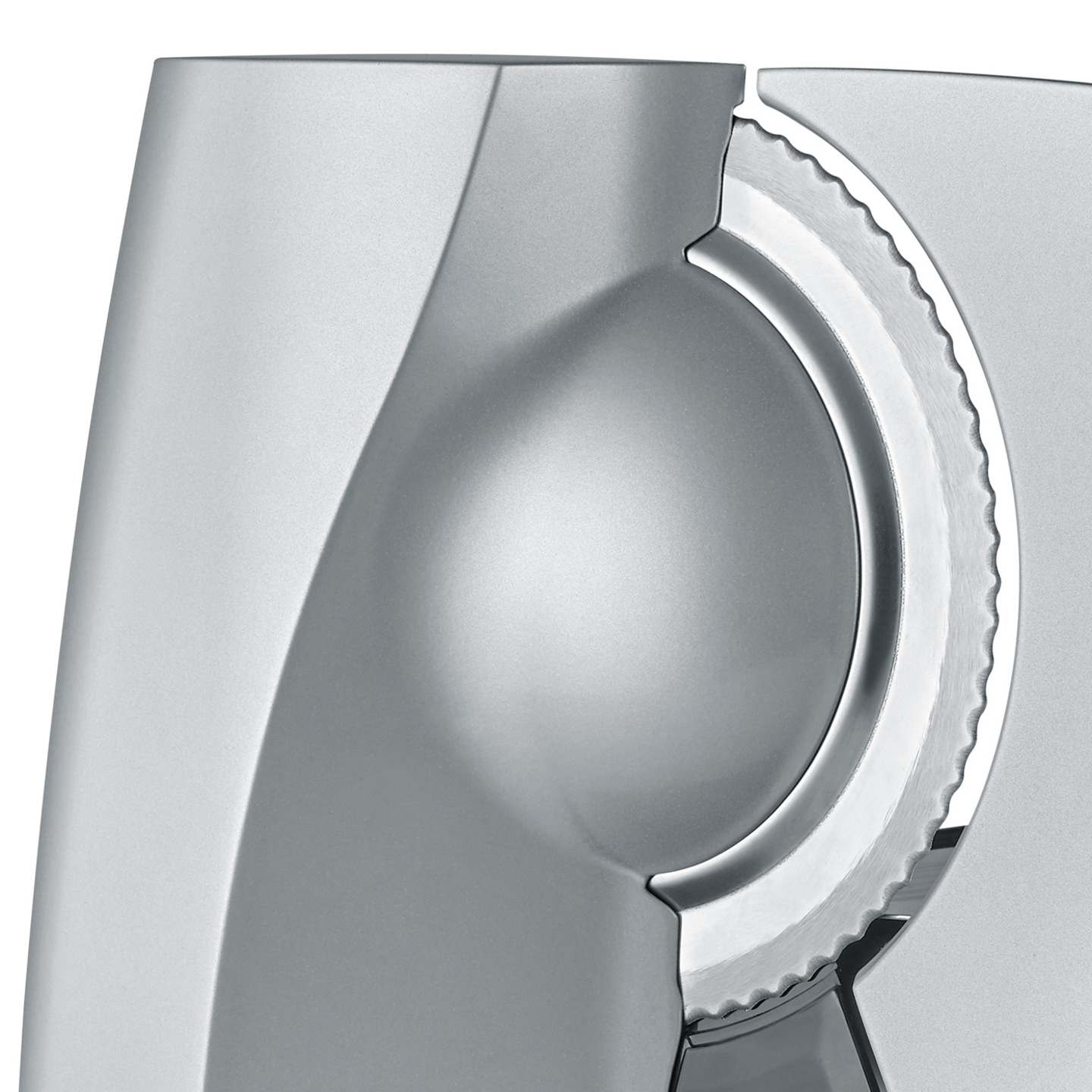 Primo piano di un'affettatrice d'argento con lama seghettata e superficie liscia, design moderno