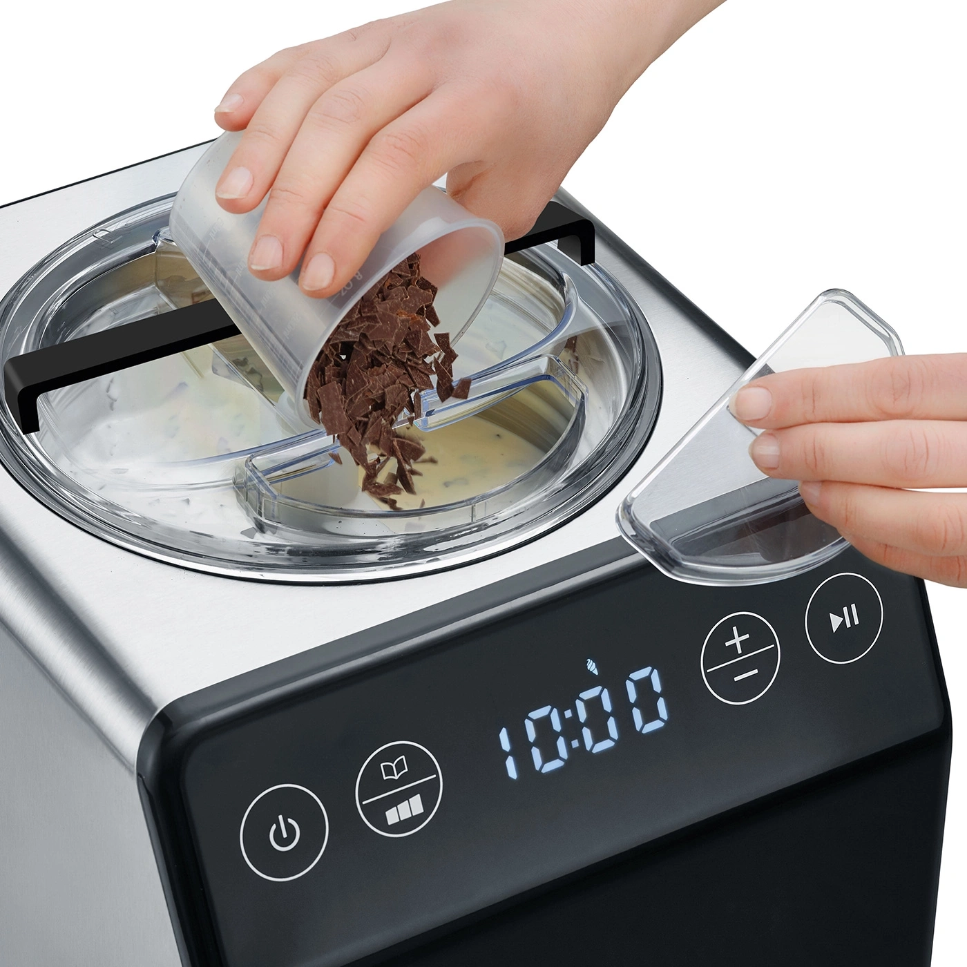 Hands adding chocolate pieces to an ice cream maker, time 10:00, close-up.