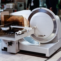 Meat slicer with bread. Stainless steel, professional, kitchen, food preparation.