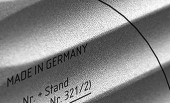 Made in Germany, testo su superficie metallica, primo piano, bianco e nero, identificazione prodotto.