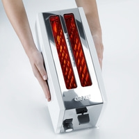 Grille-pain blanc avec détails chromés, tenu par des mains, logo GRAEF, fentes à pain