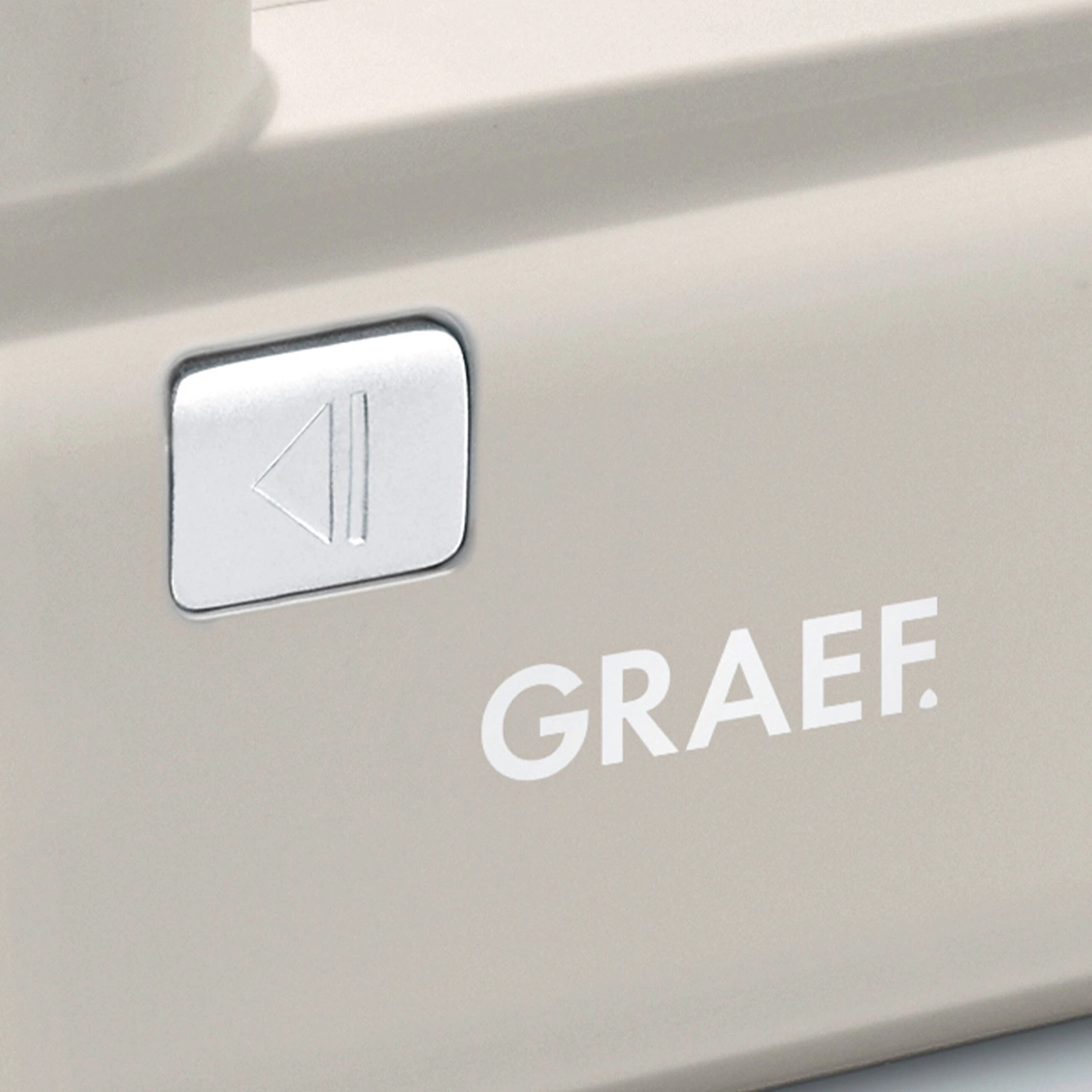 Appareil Graef avec bouton lecture et logo. Couleur beige, détail en gros plan.