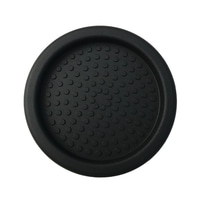 Black drink coaster with circular indentations, close-up detail, isolated object