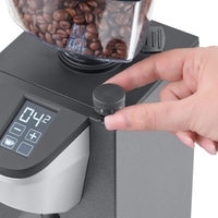 Coffee grinder with beans and hand turning knob, close-up shot