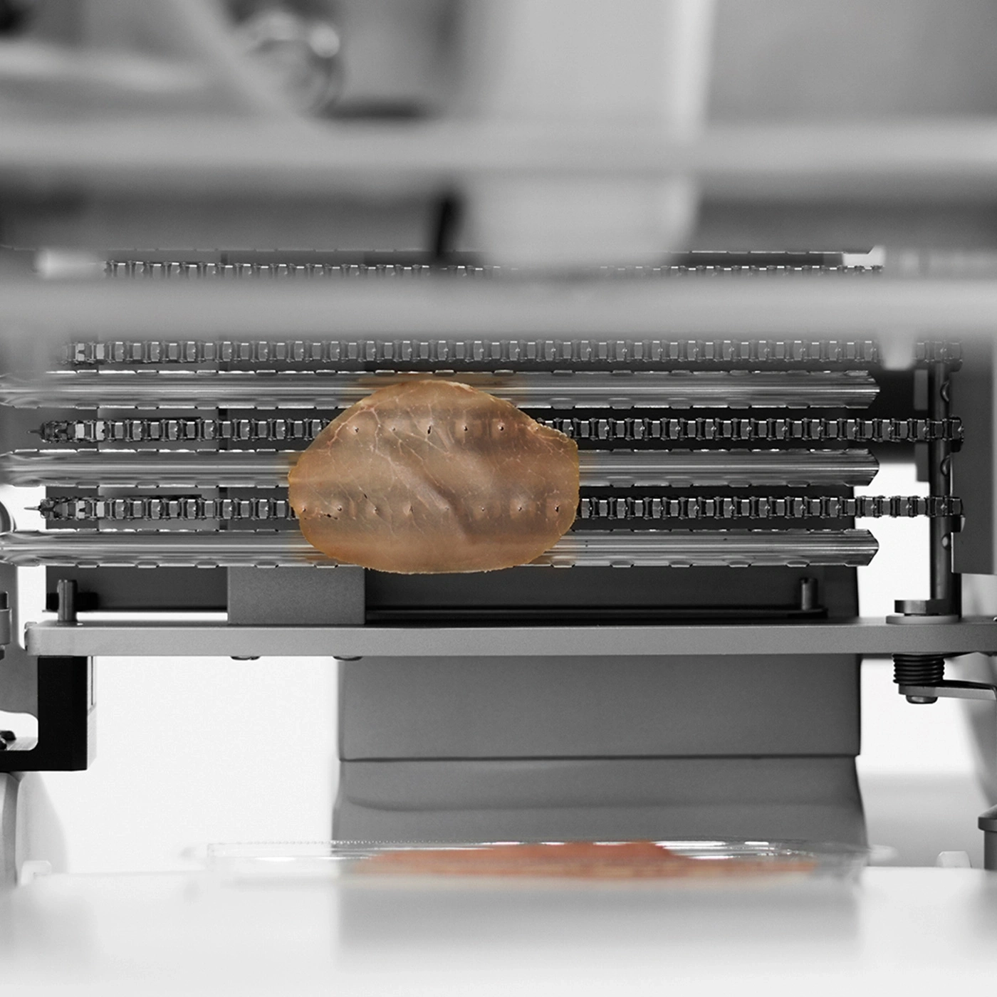 Macchina con fetta di carne. Produzione, industria alimentare, tecnologia, primo piano.