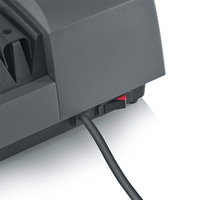 Close-up of a gray device with a red switch and a black cable