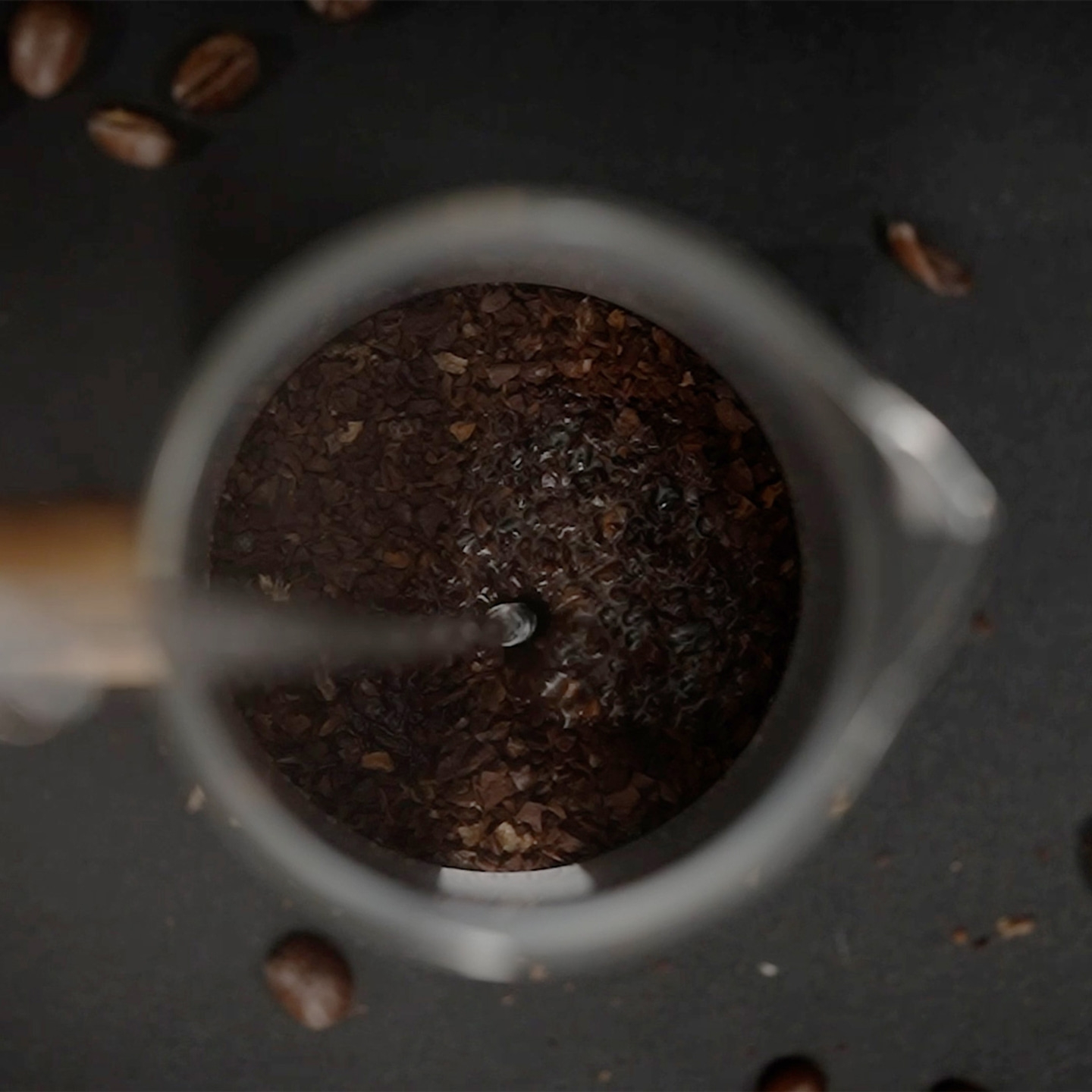Coffee grounds with water in a glass container, close-up shot