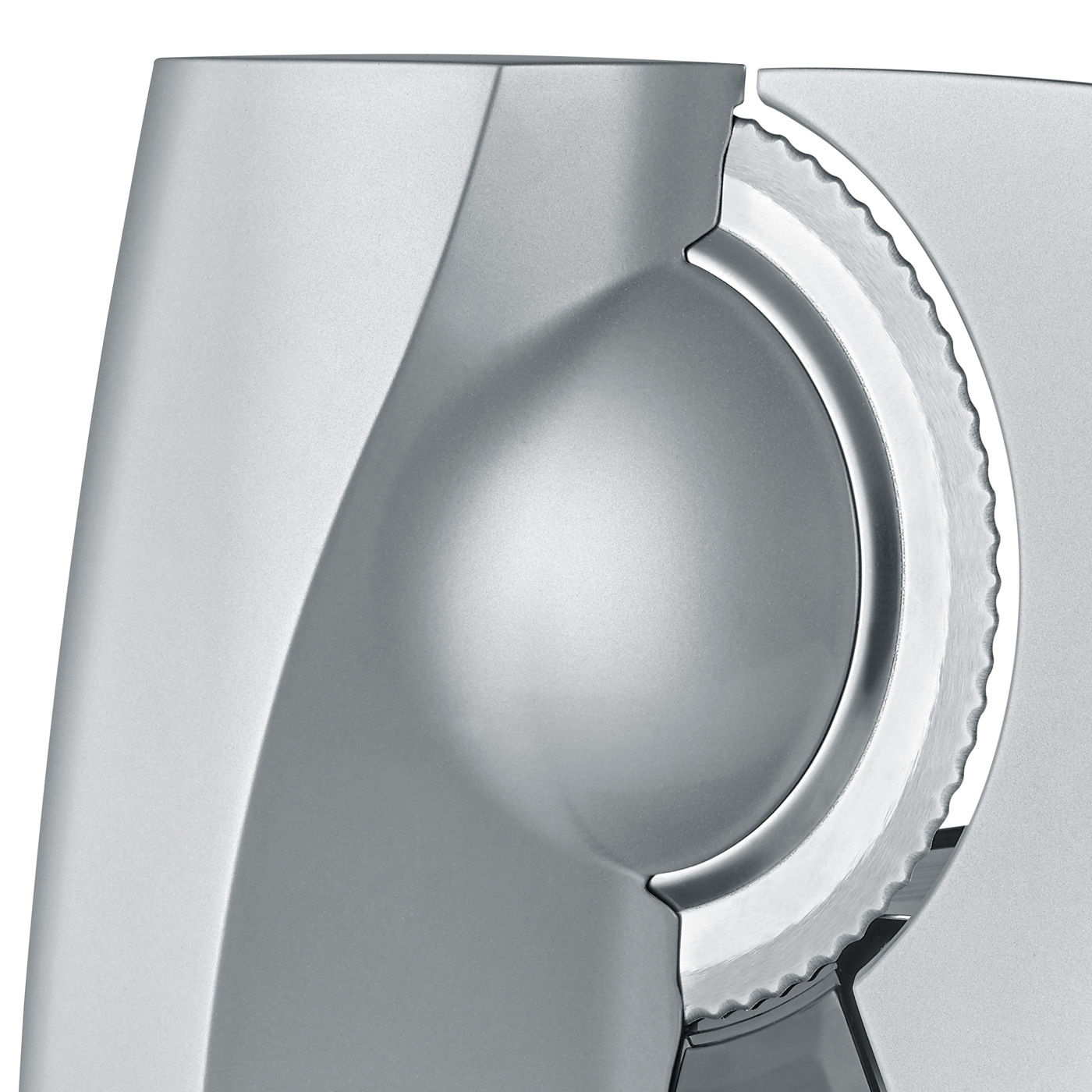 Primo piano di un'affettatrice d'argento con lama seghettata e superficie liscia, design moderno