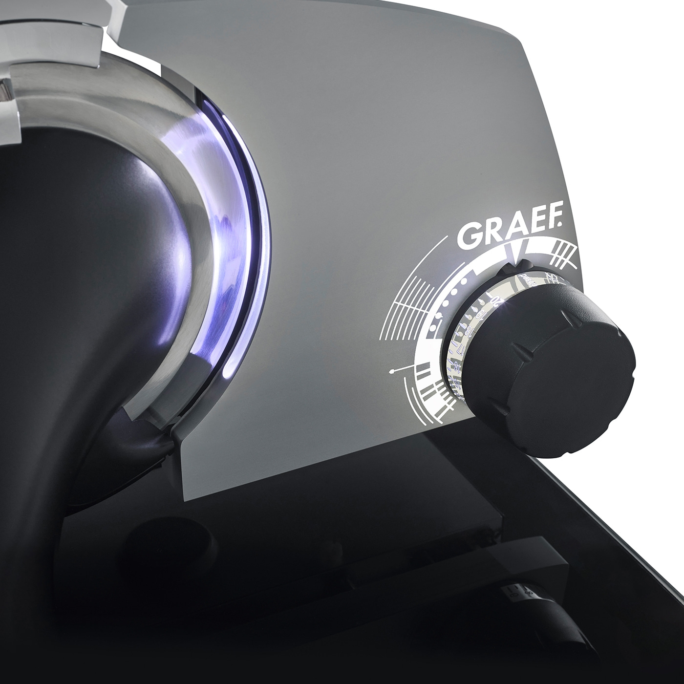 Détail de la trancheuse Graef, bouton, surface grise, lumière bleue, nom de la marque, machine