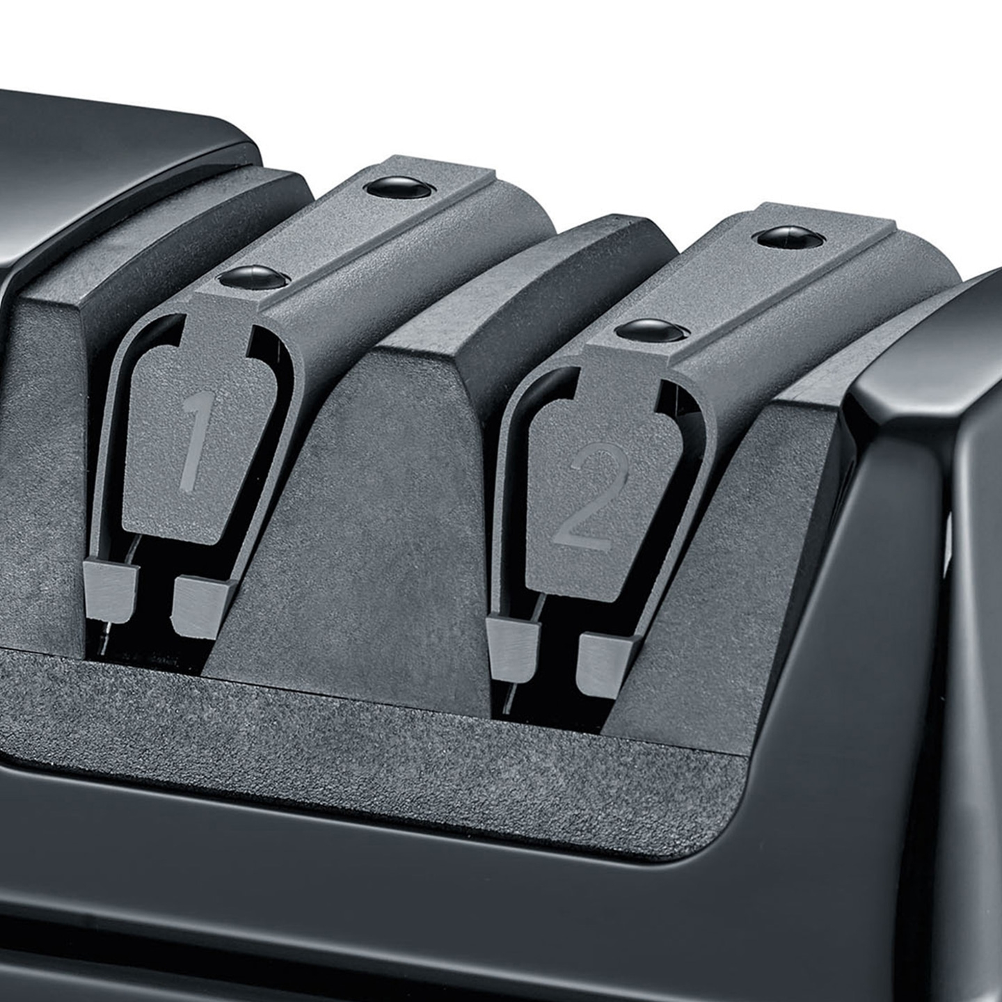 Close-up of a black knife sharpener with two slots labeled 1 and 2.